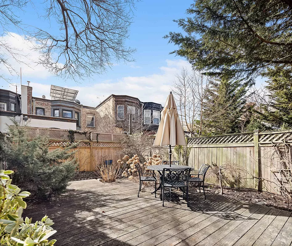 rear garden with wood deck ringed with planting beds