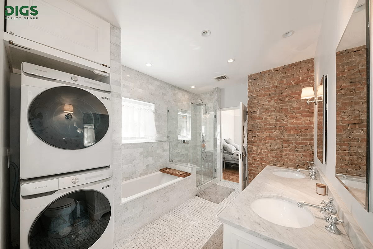 bathroom with a double vanity and stackable washer and dryer