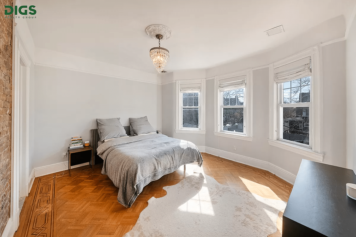 bedroom with wood floor, picture rail and some exposed brick