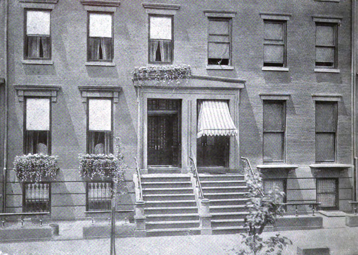 black and white photo showing a house with window boxes and one without