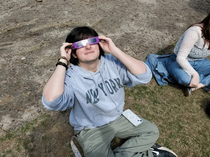 student with eclipse glasses on