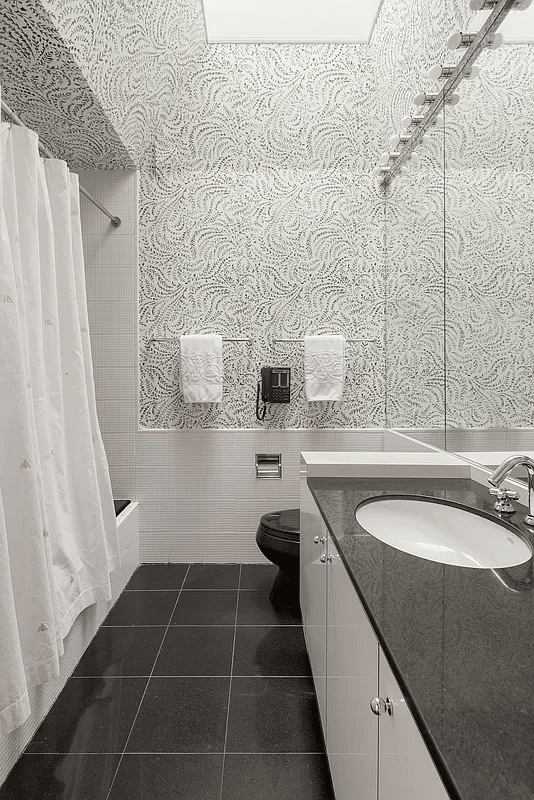 bathroom with black floor tiles and black toilet and tub