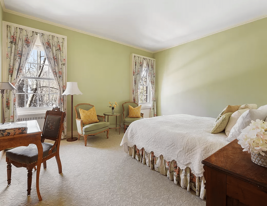 bedroom with green walls and neutral carpet