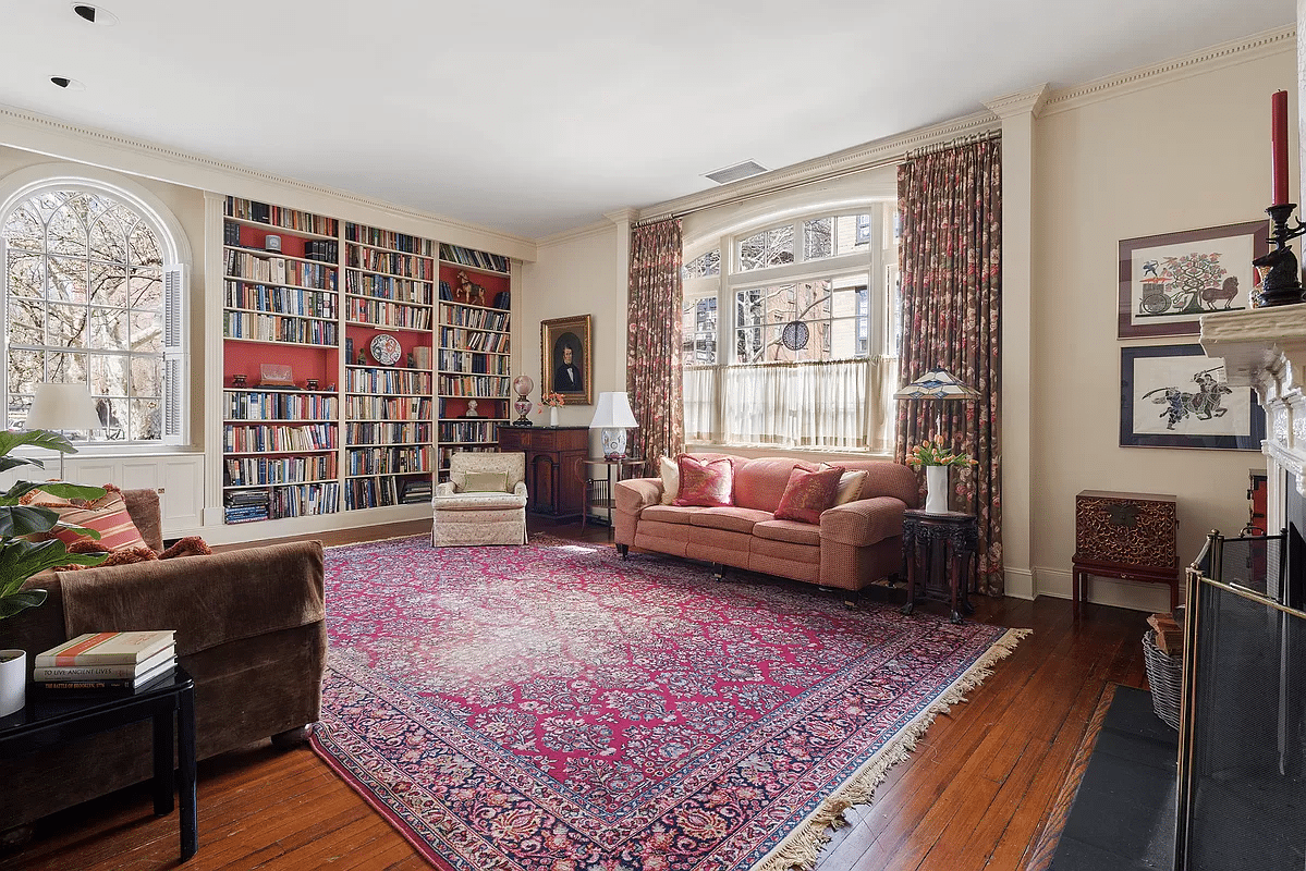 living room with arched windows, wood floor, and built-in bookshelves