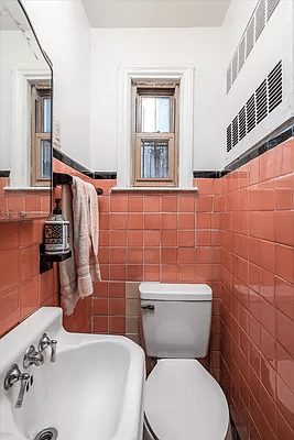 bathroom with white fixtures and pink wall tiles