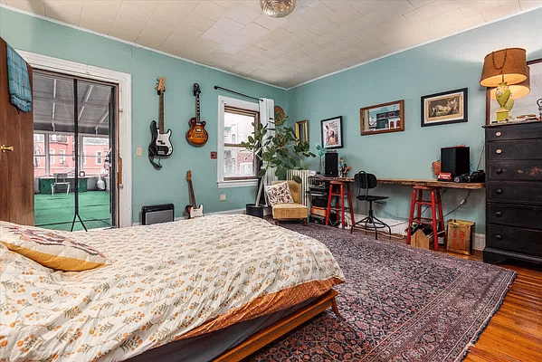 bedroom with blue walls, ceiling tiles and access to the sunroom/sleeping porch