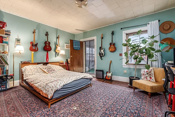 bedroom with blue walls, ceiling tiles and access to the sunroom/sleeping porch