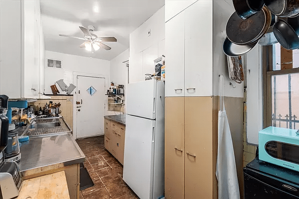 windowed kitchen with stainless steel counters and a door to the rear yard