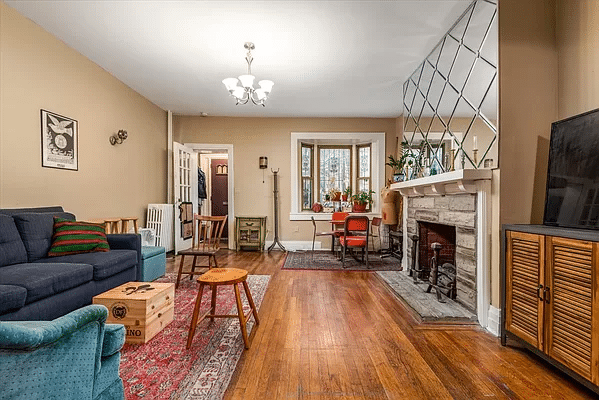 living room with wood floor, mantel and bay window