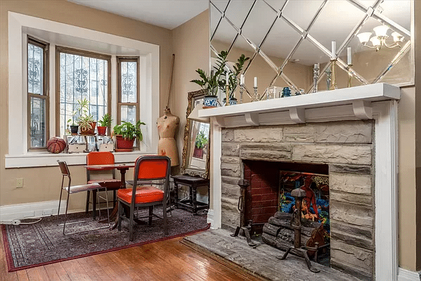 street-facing living room with mirrored wall above a mantel