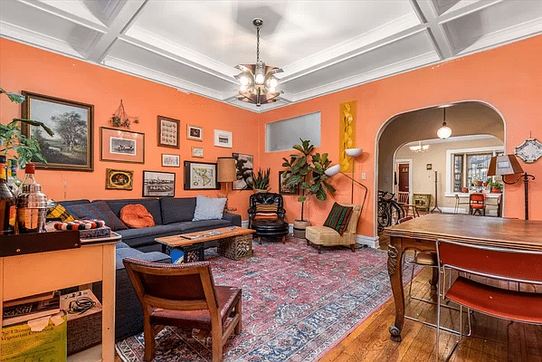 former dining room set up as a living room with beamed ceiling and orange walls