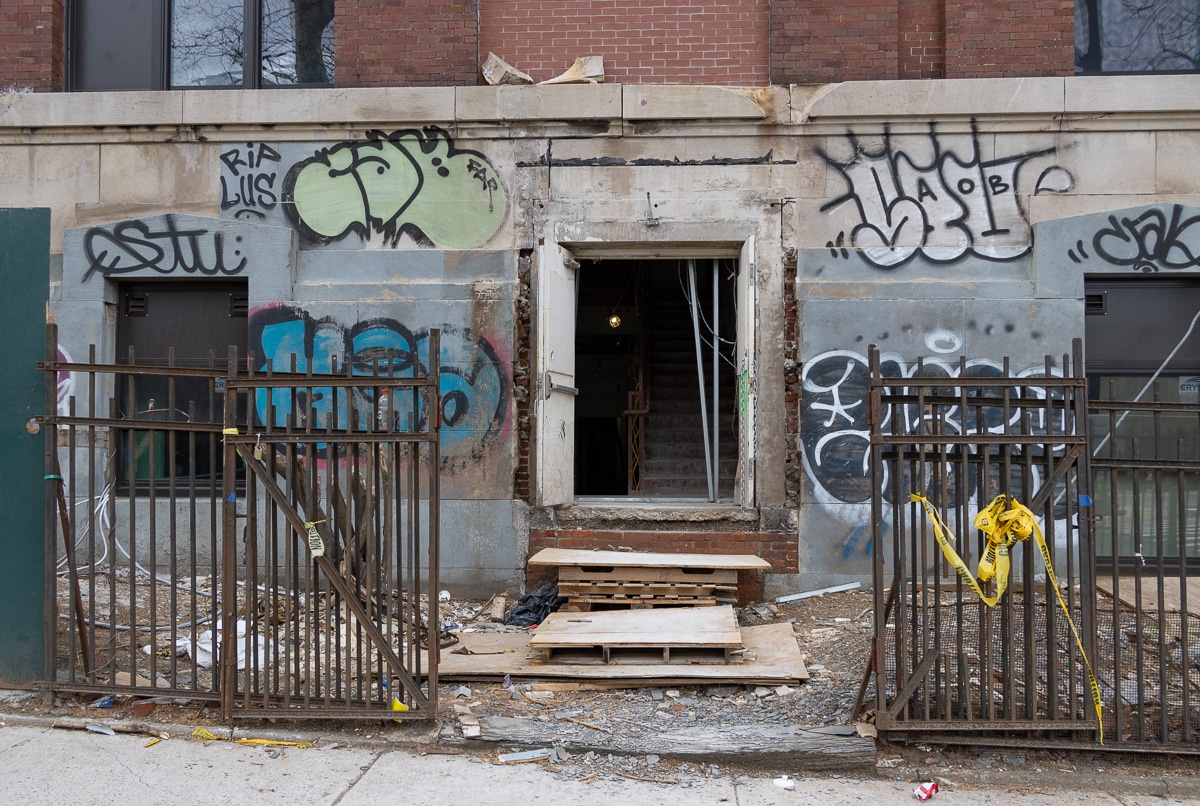 an open entrance door surrounded by graffiti