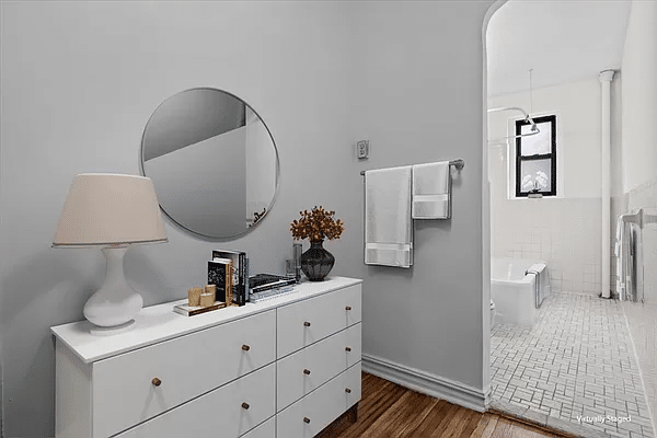 virtually staged dressing area with a dresser and view into bathroom