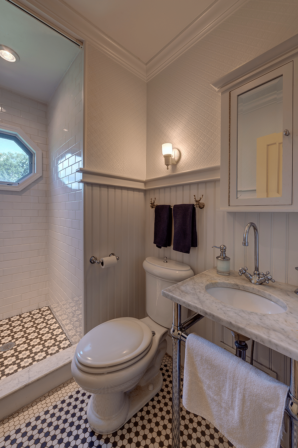 bathroom with marble sink, walk in shower and black and white tile floor