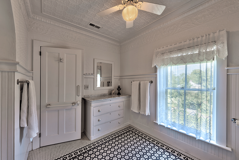 bathroom with tin ceiling and black and white tile floor