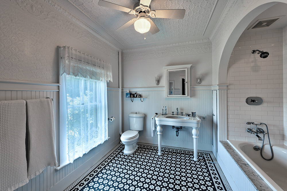 bathroom with beadboard, white subway tile and a tin ceiling