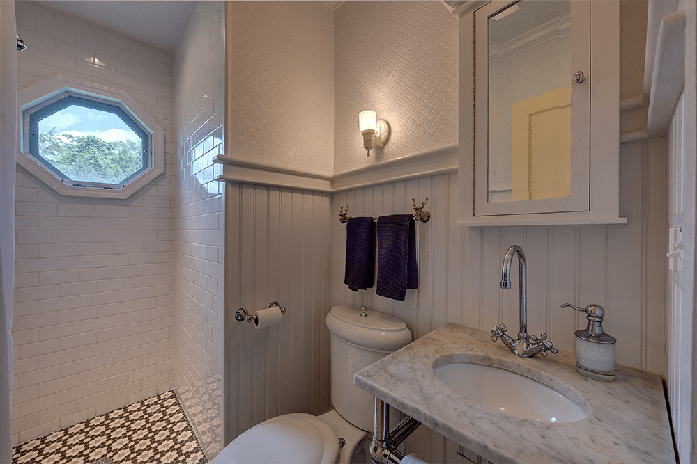 bathroom with marble sink, walk in shower and black and white tile floor