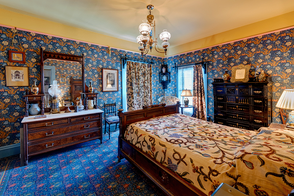 bedroom with patterned wallpaper and carpet