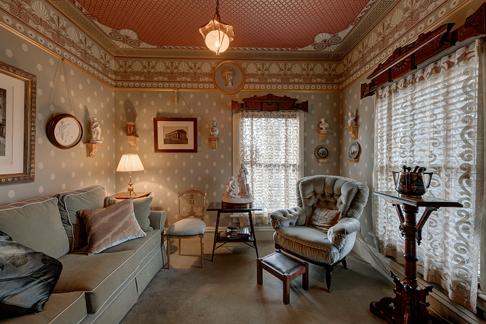 bedroom set up as a den with wall and ceiling papers, beige carpet