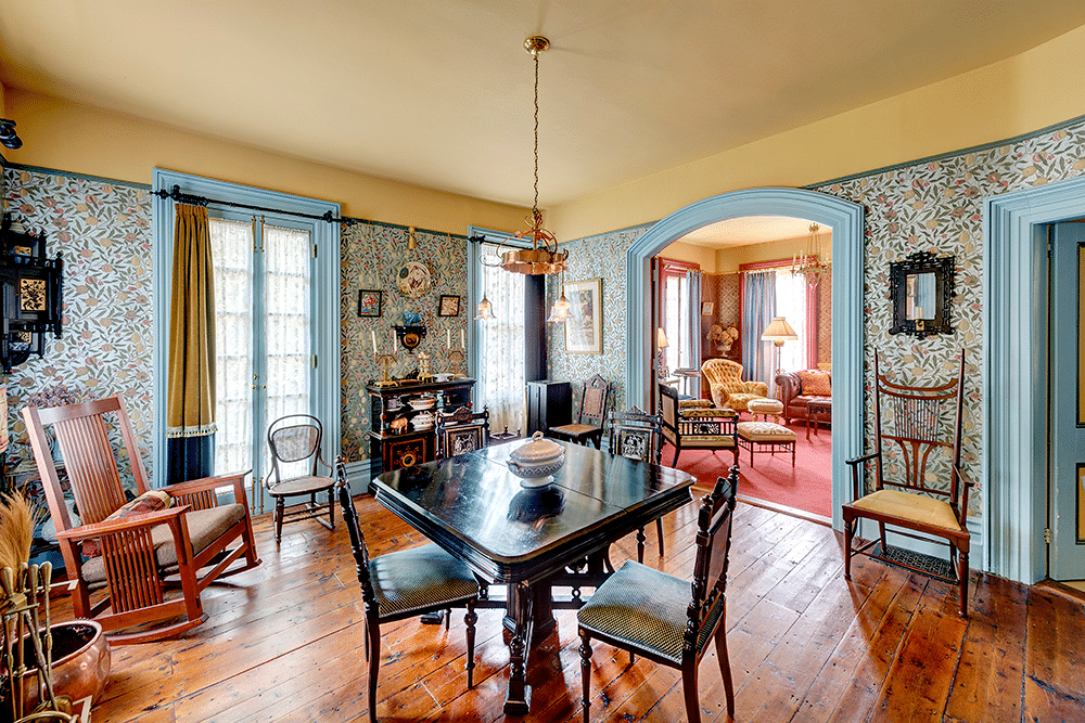 dining room with William Morris wallpaper, wood floor and robins egg blue trim