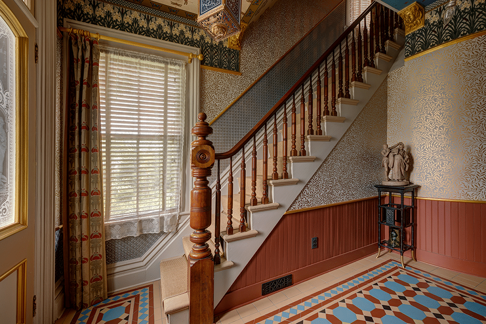 entry with encaustic tile, beadboard, and wallpaper