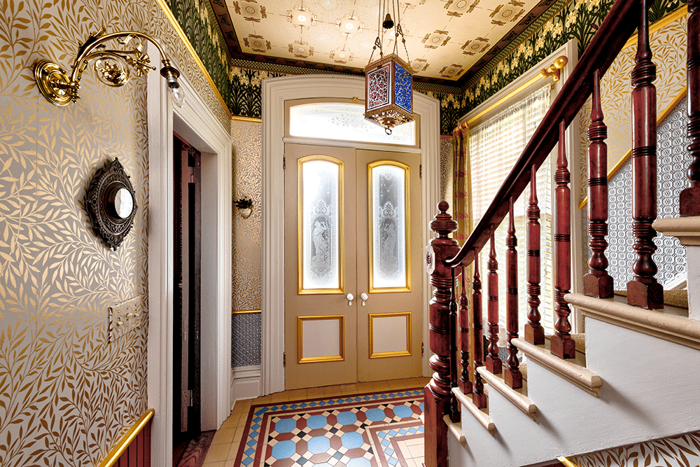 view to double front doors with etched glass and a foyer with encaustic tiles