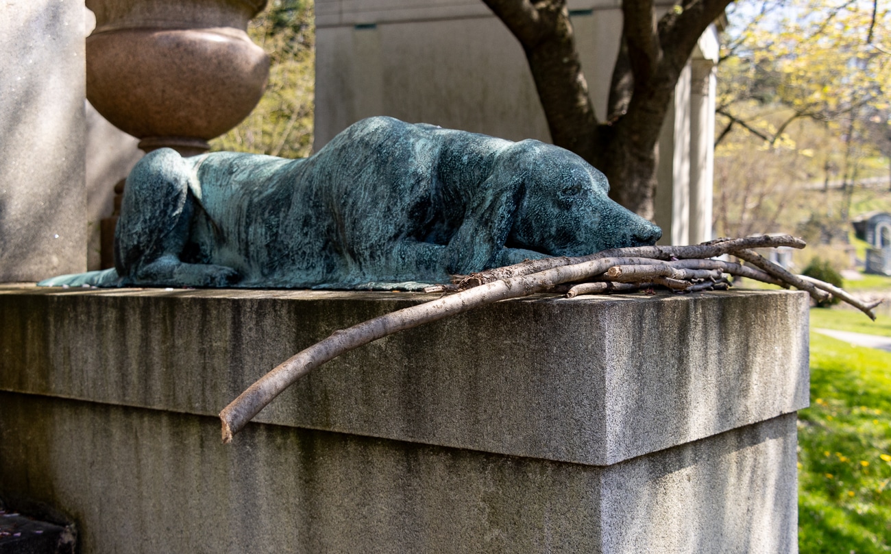 green-wood cemetery - dog sculpture with sticks placed in front