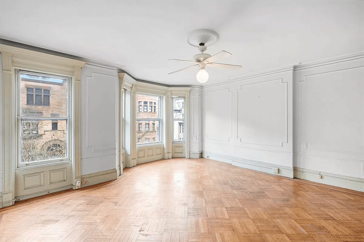 bedroom with wall moldings, wood floor