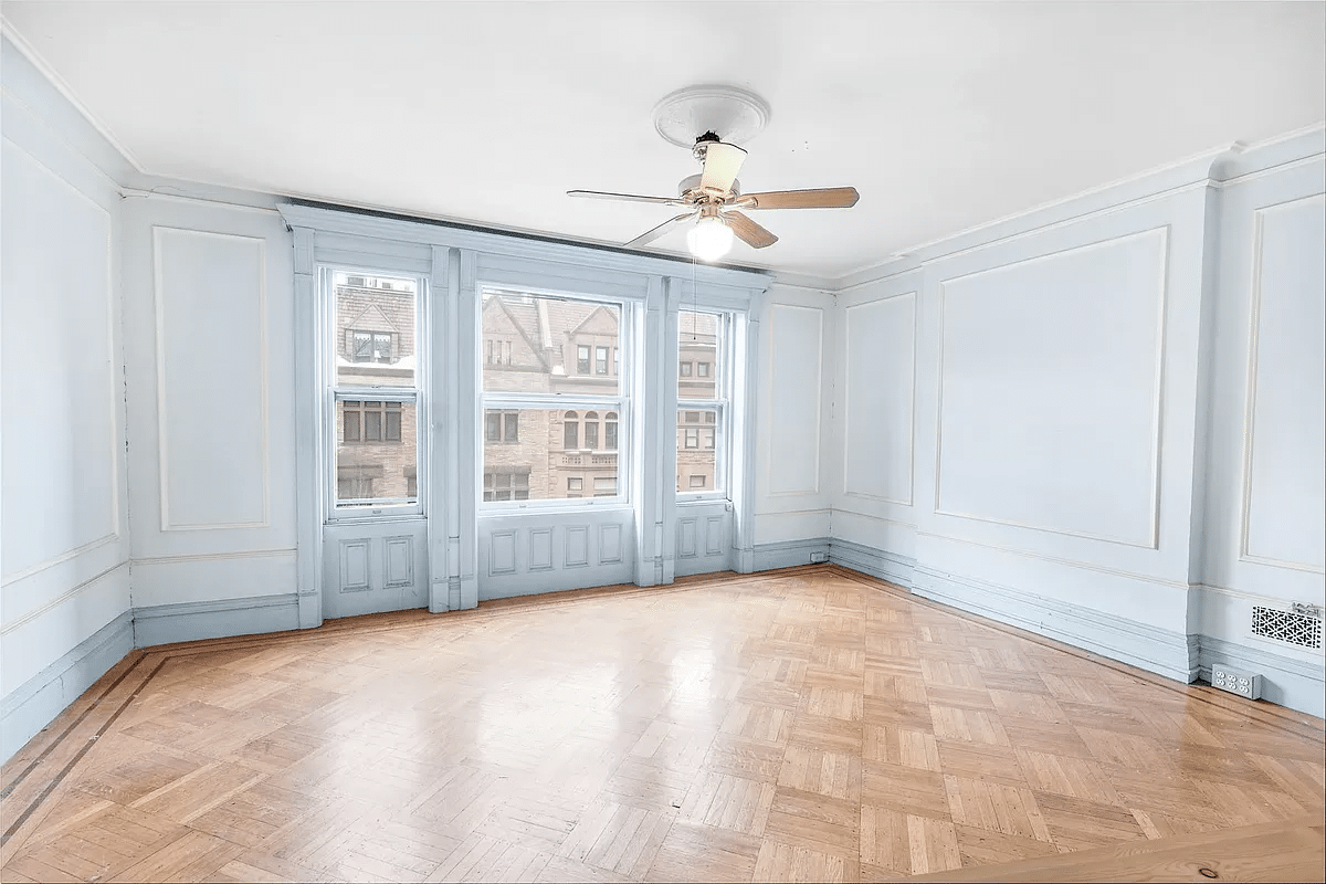 bedroom with wall moldings, wood floor