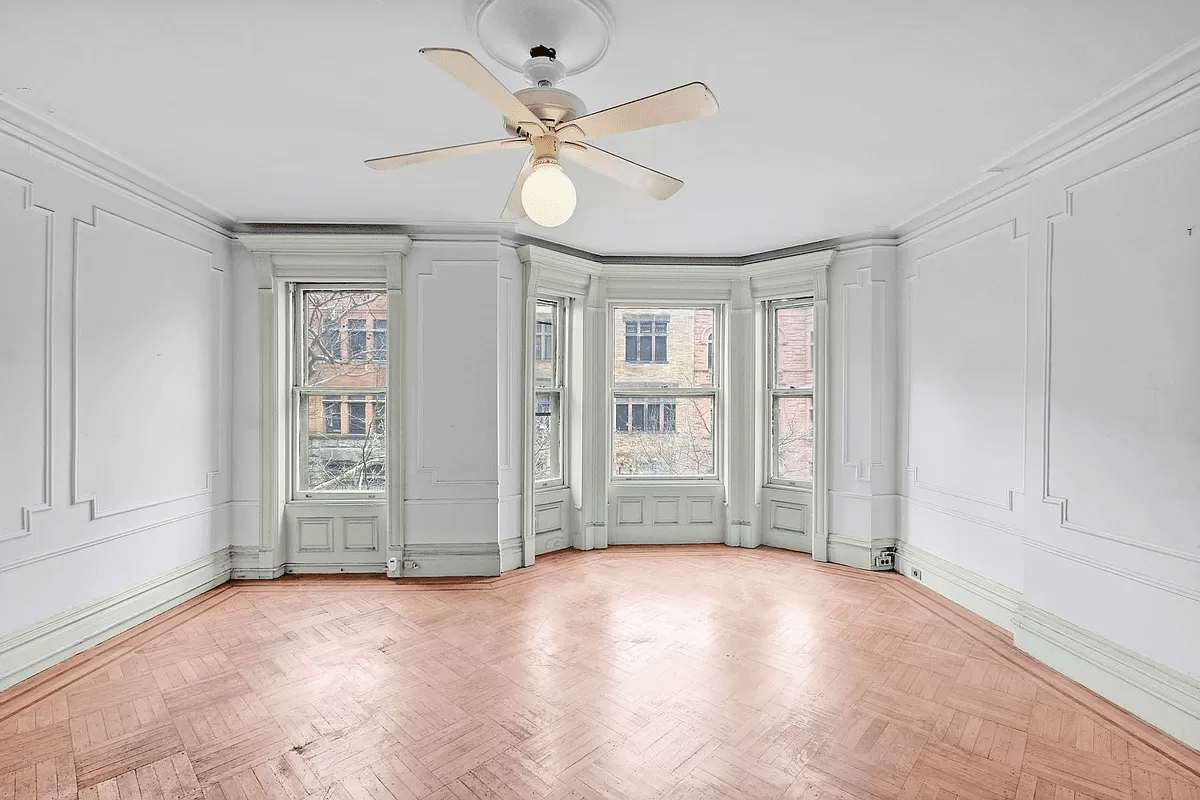 bedroom with wall moldings, wood floor