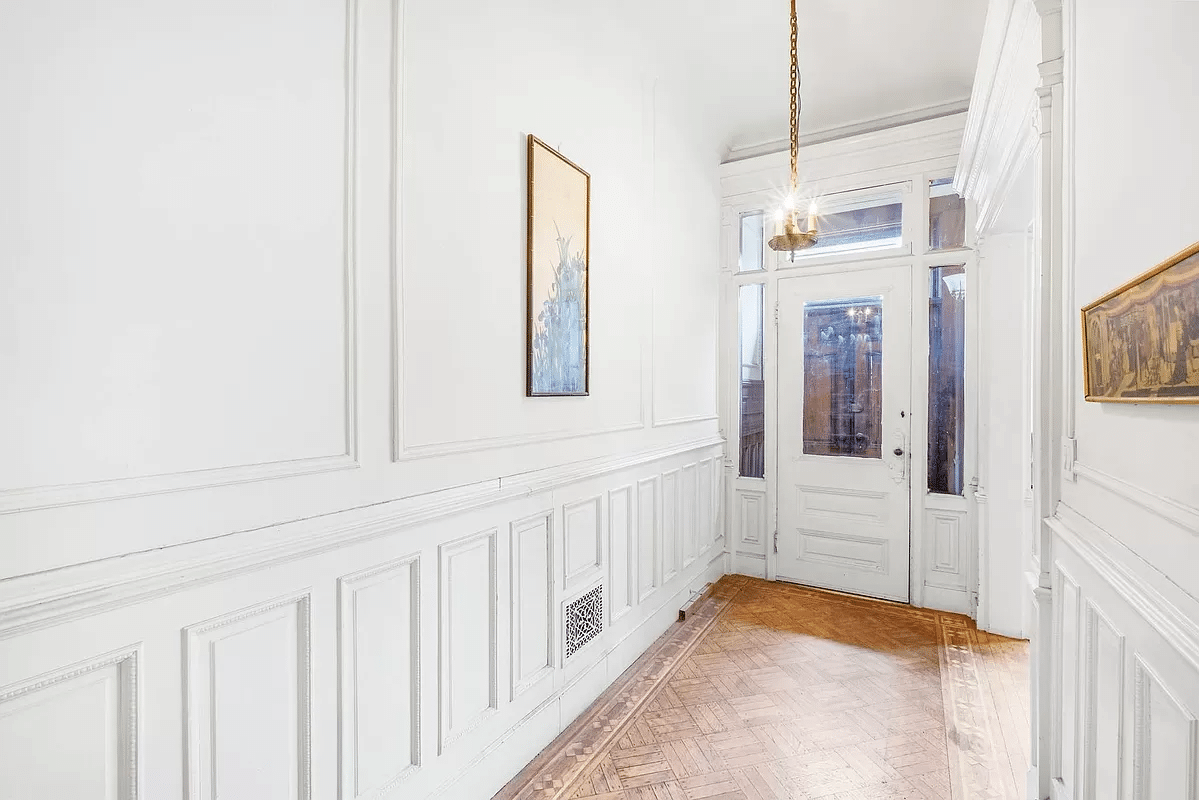 entry with white painted wainscoting, moldings