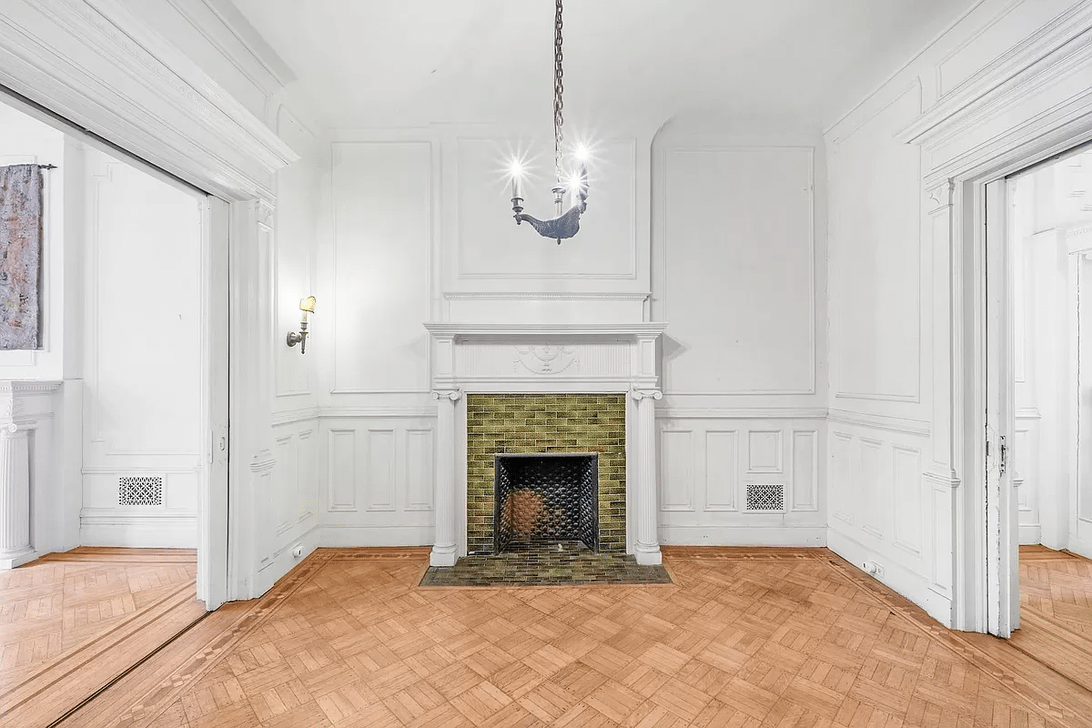 middle parlor with wainscoting and columned mantel with green tile surround
