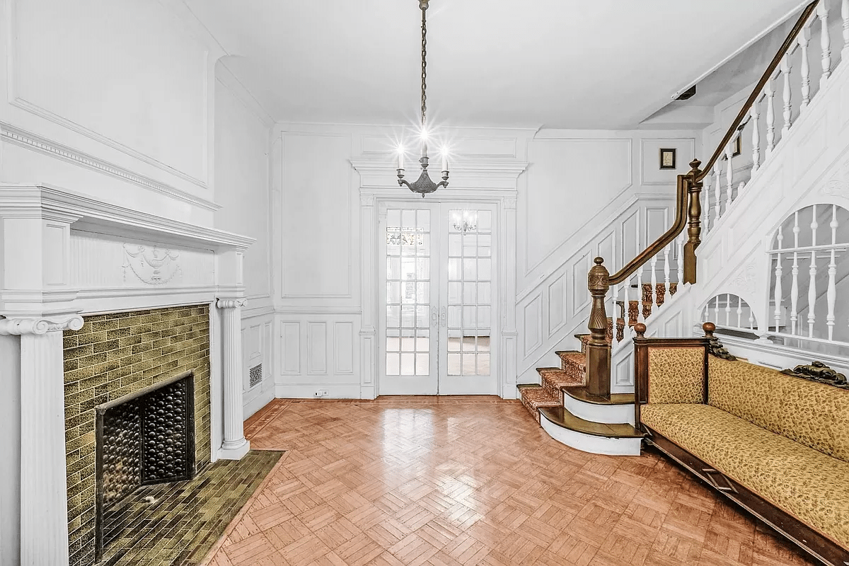 middle parlor with white painted molding, wainscoting and columned mantel