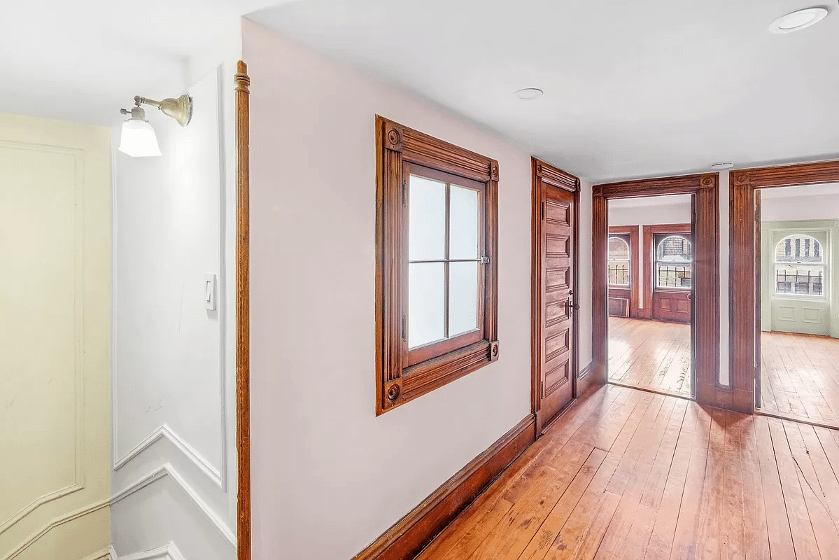 upstairs hall with moldings and wood floor