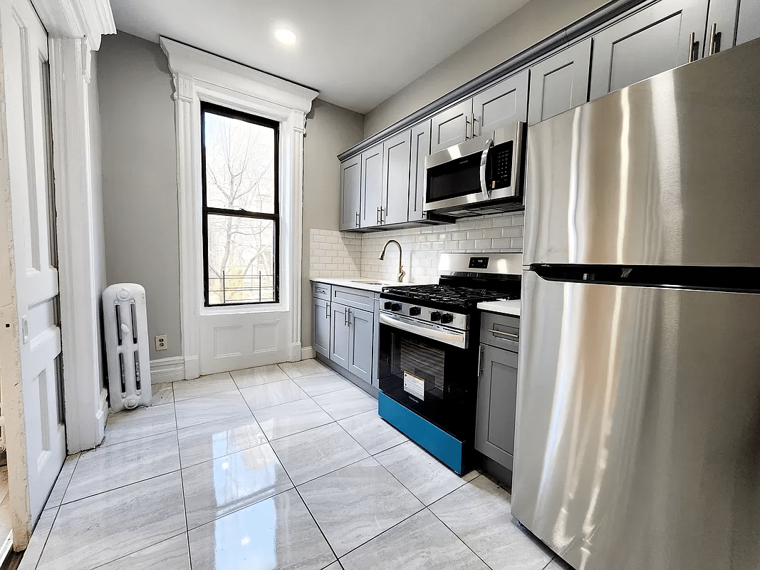 kitchen with gray cabinets, gray tile floor and white subway tile