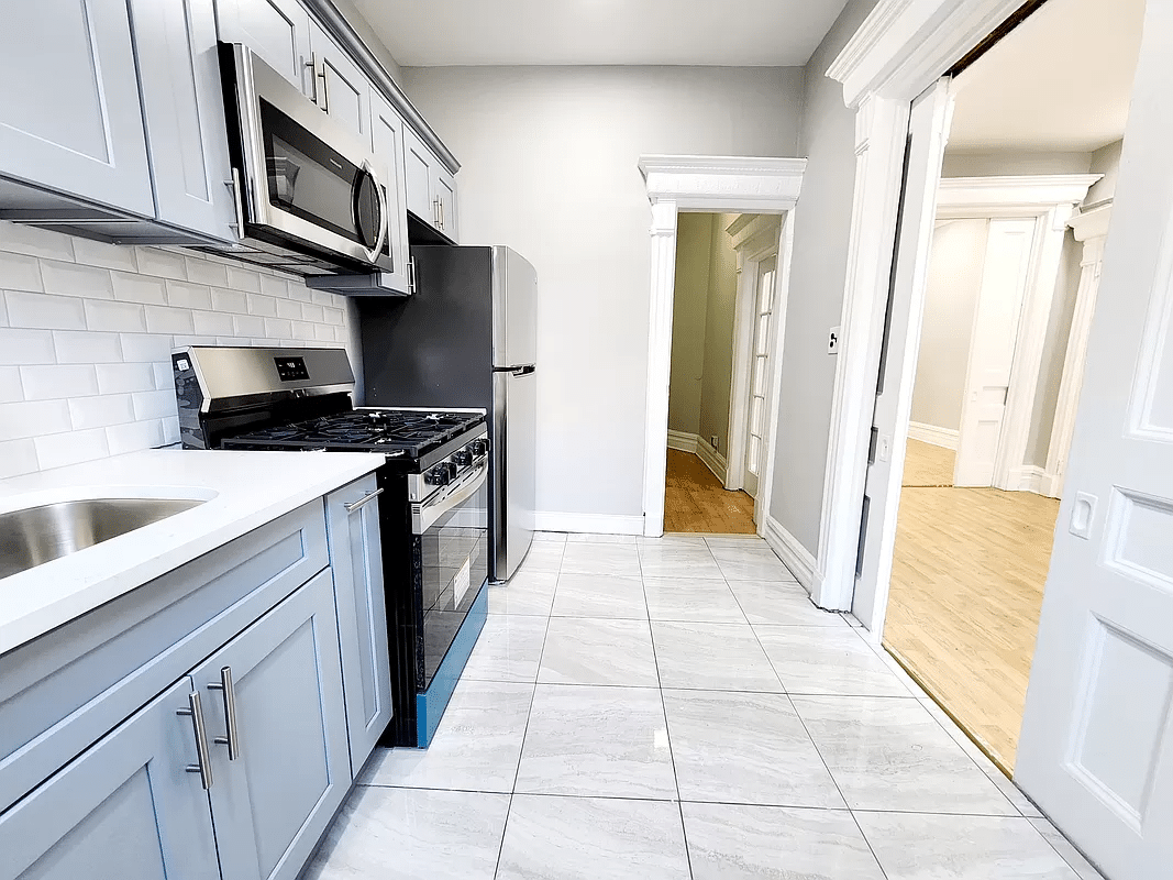 kitchen with gray cabinets, gray tile floor and white subway tile