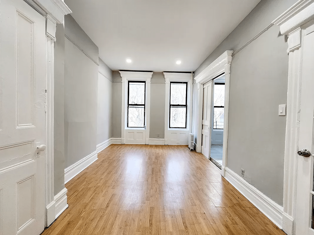 living room with gray walls, white trim, pocket doors to kitchen