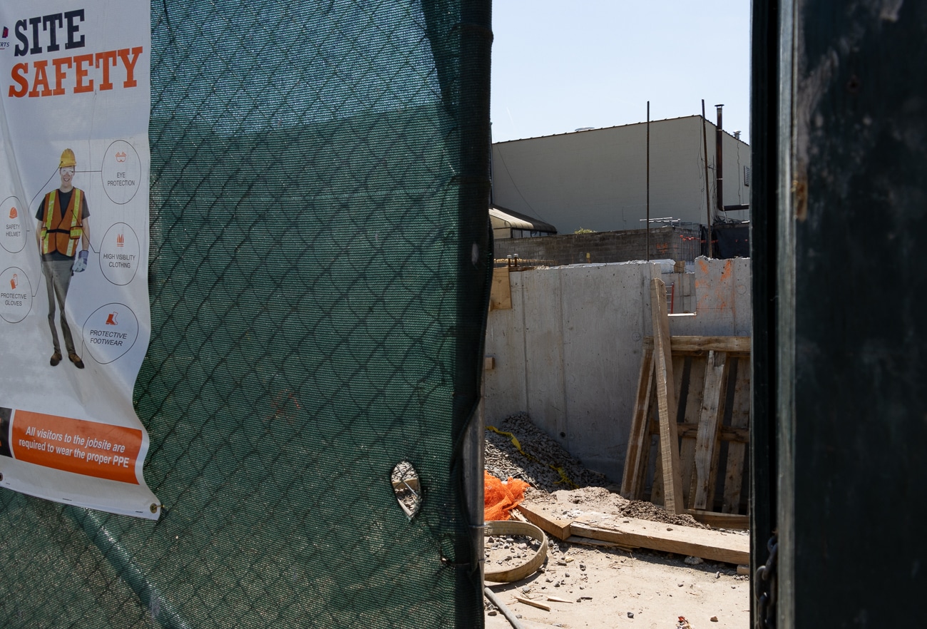 glimpse through the construction fence to a concrete wall