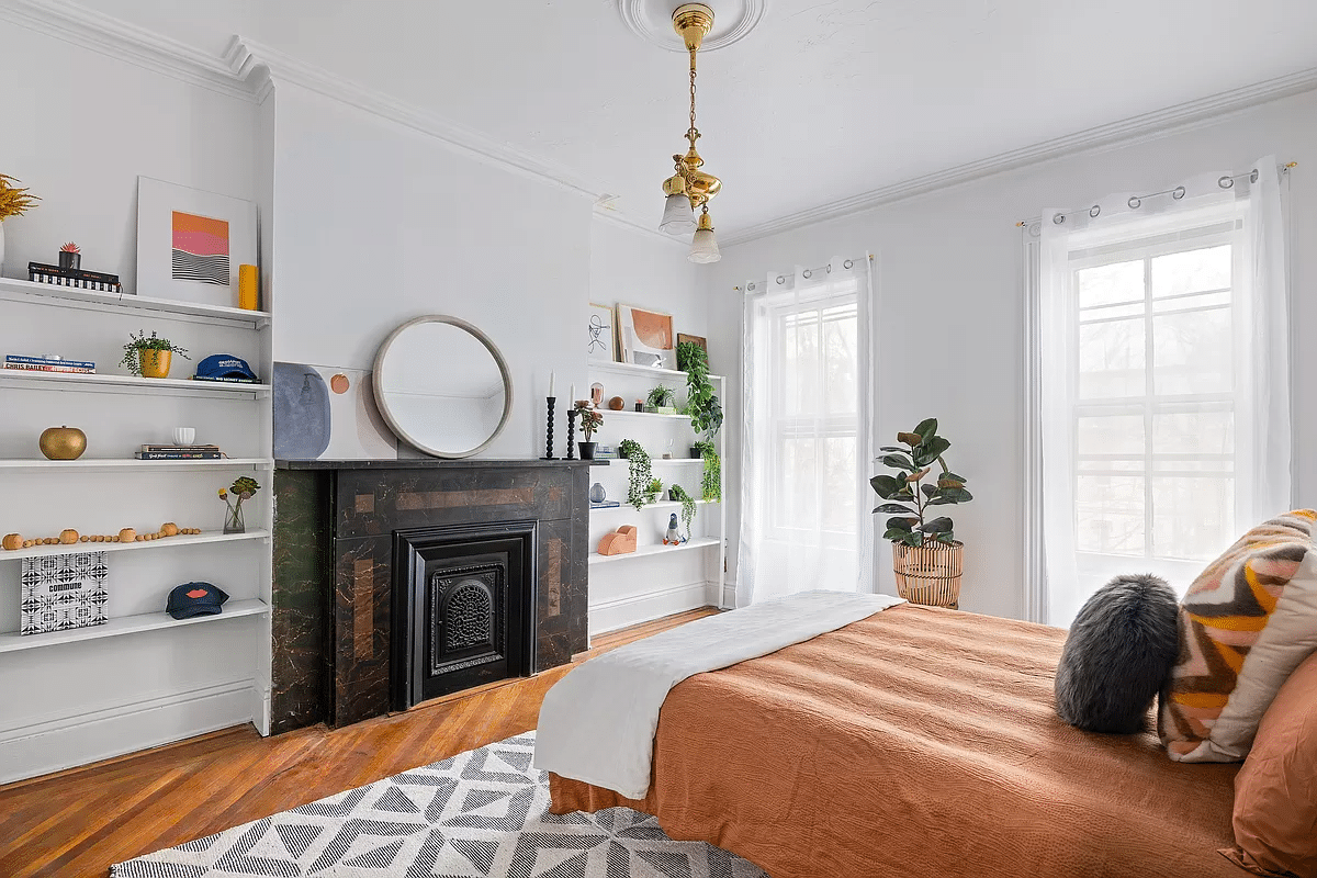 bedroom with mantel and wood floor