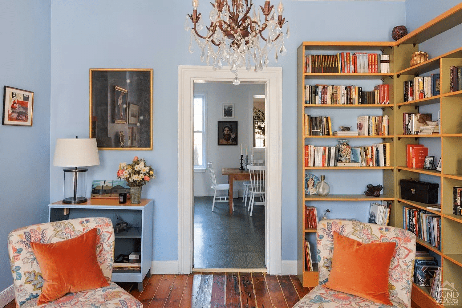 living room with chandelier, blue walls and view into kitchen