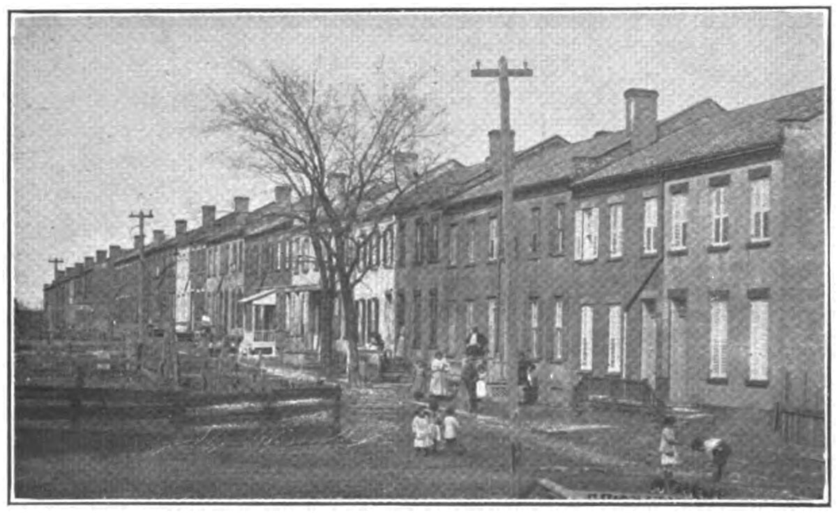 black and white photo showing two story brick row houses
