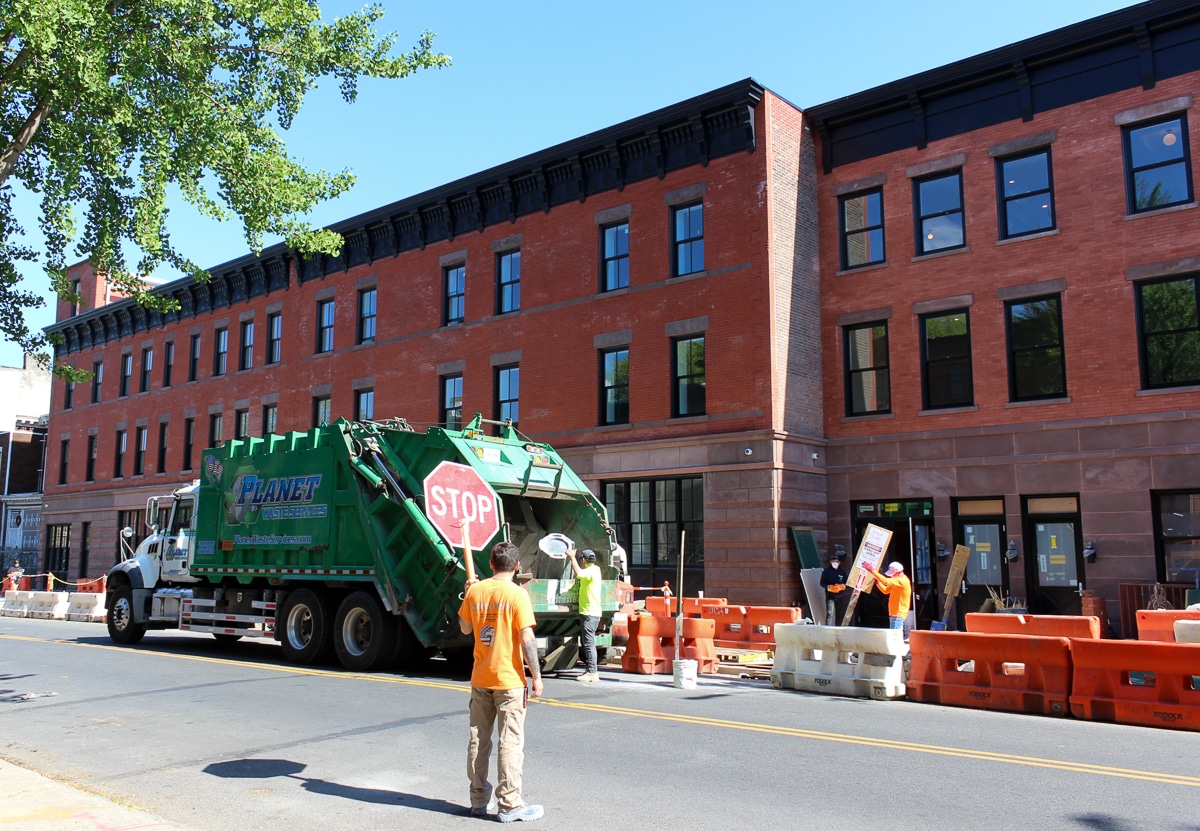 bed stuy - garbage truck in front of brick and brownstone houses