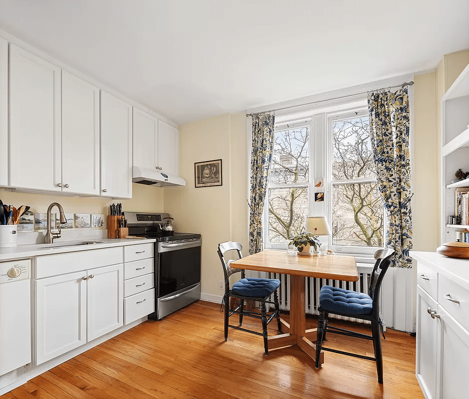 windowed kitchen with wood floors and white cabinets
