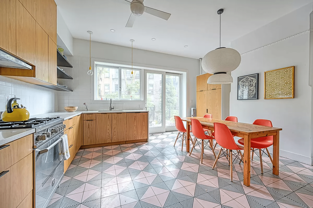 kitchen with pink and black geometric floor tile, wood cabinets, door to garden