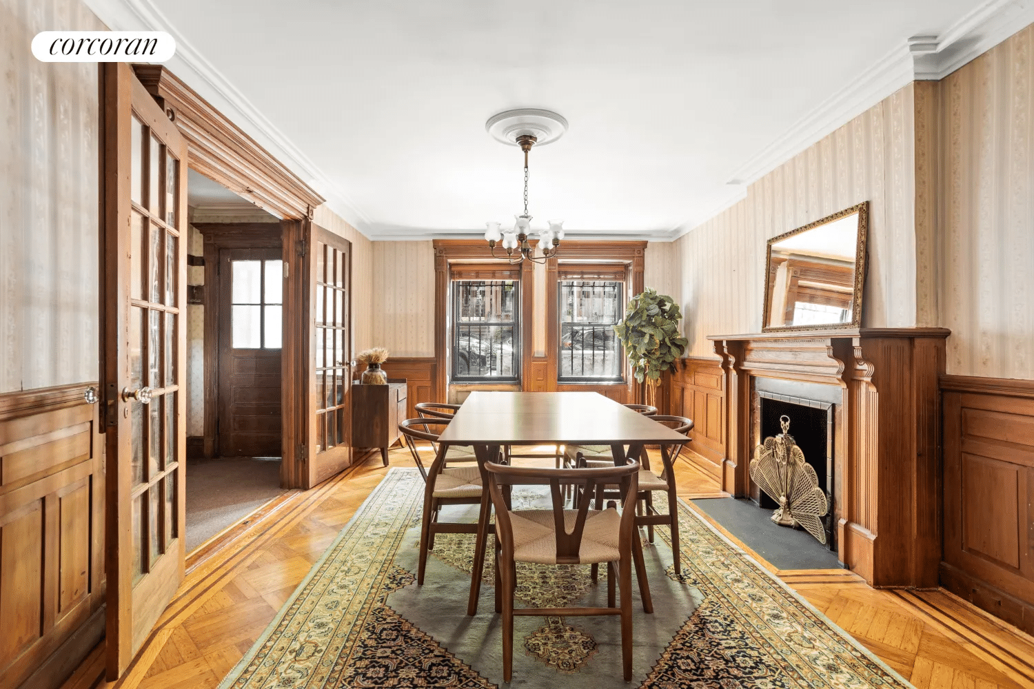 garden level dining room with wainscoting, mantel and french doors to hallway