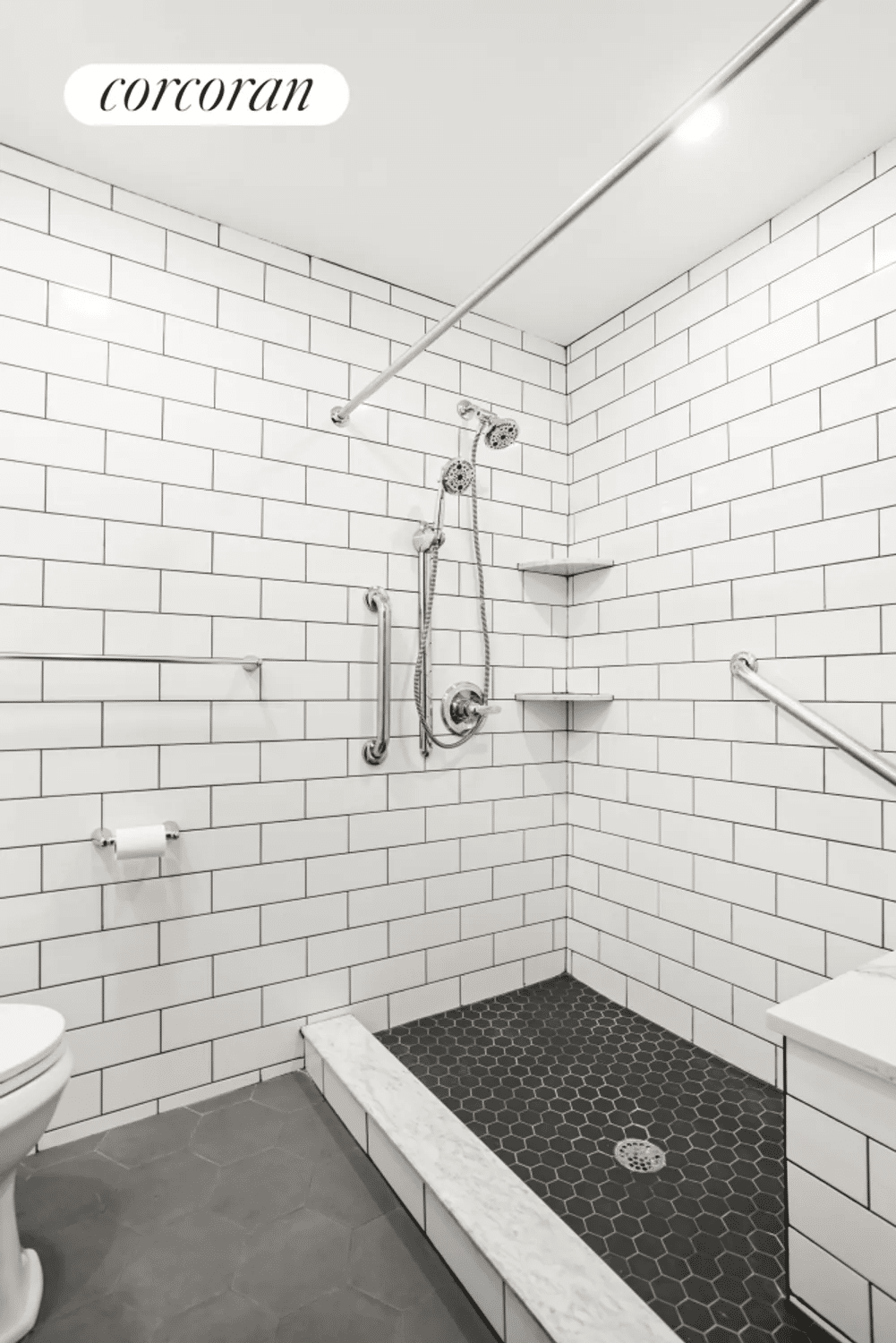 renovated bathroom with white and black tile and a shower