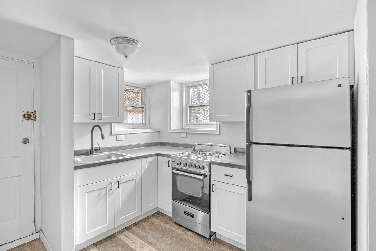 basement kitchen with white cabinets, vinyl flooring