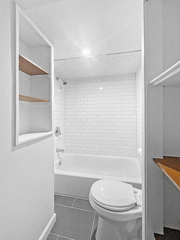 bathroom with white fixtures, large gray floor tile