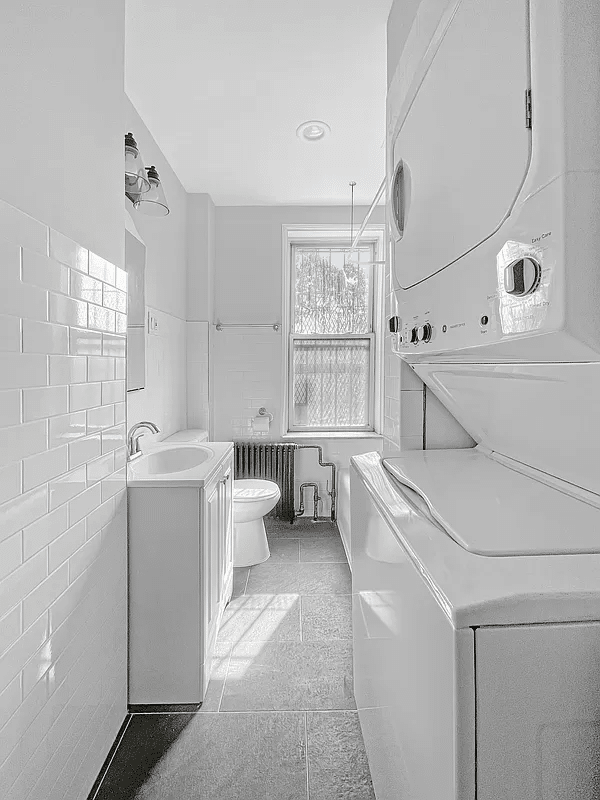 bathroom with stacked laundry