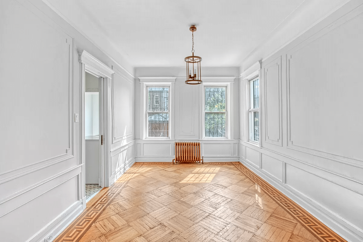 dining room with wall moldings, door to kitchen